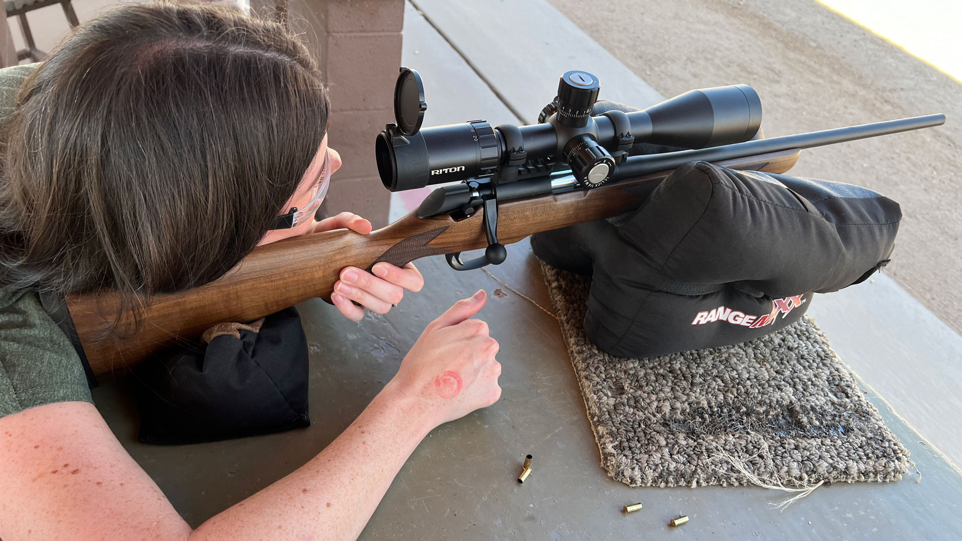 shooter at bench firing .22 rifle